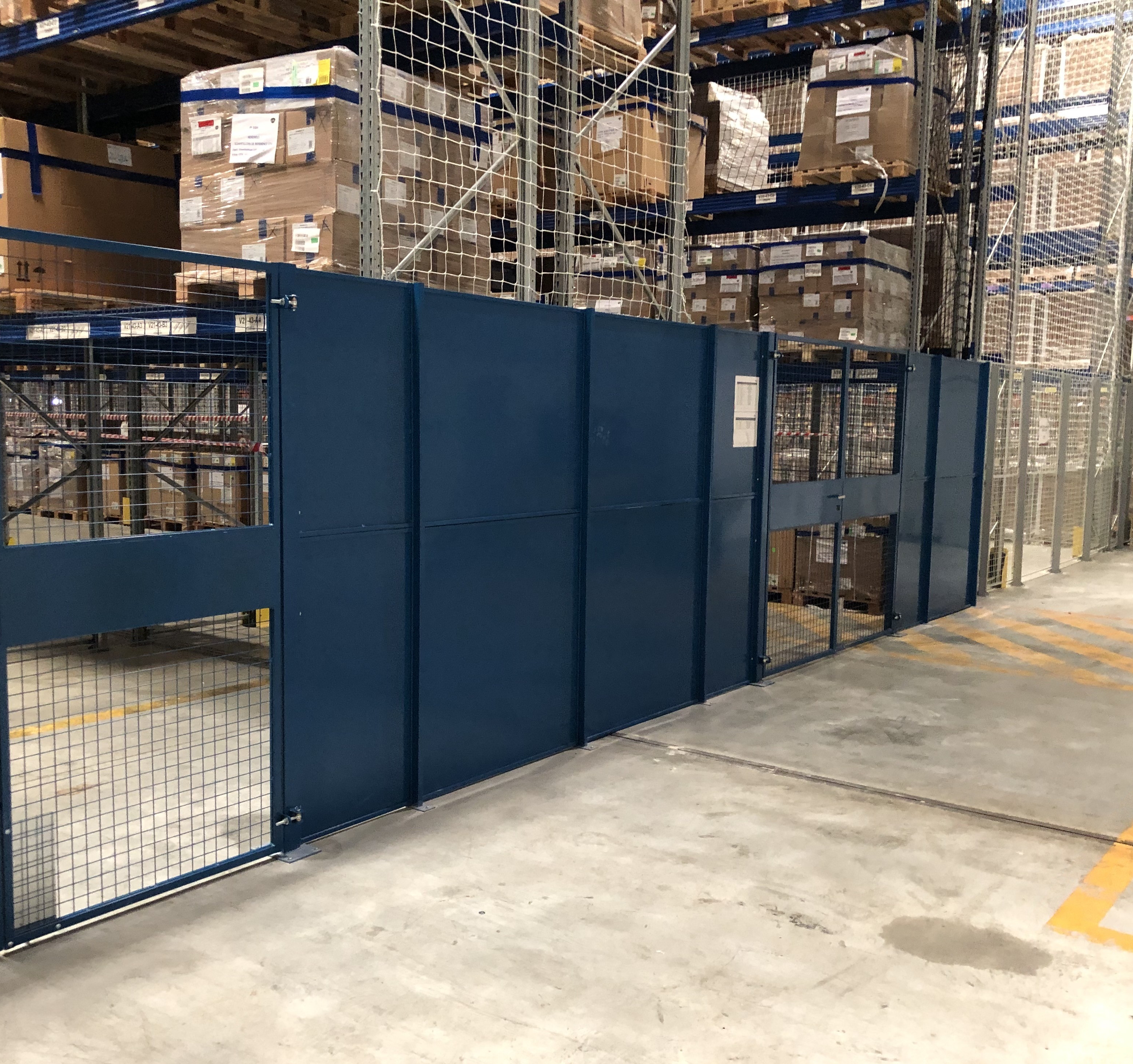 Cloison grillagée Modul+ équipée de portes battantes pour accéder à des racks de stockage sur palettes
			