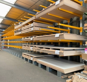 Planches stockées en intérieur sur des bras de rayonnage cantilever
			