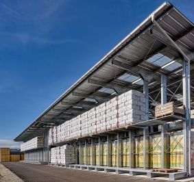 Palettes stockées sur des racks cantilever avec caillebotis et auvent
			