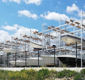 Bateaux stockés en extérieur dans un port à sec près du littoral
			