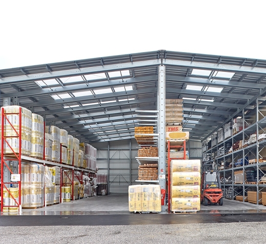 Stockage extérieur de matériaux vue de face, monté avec des racks cantilever équipés d’auvent avec des translucides
                