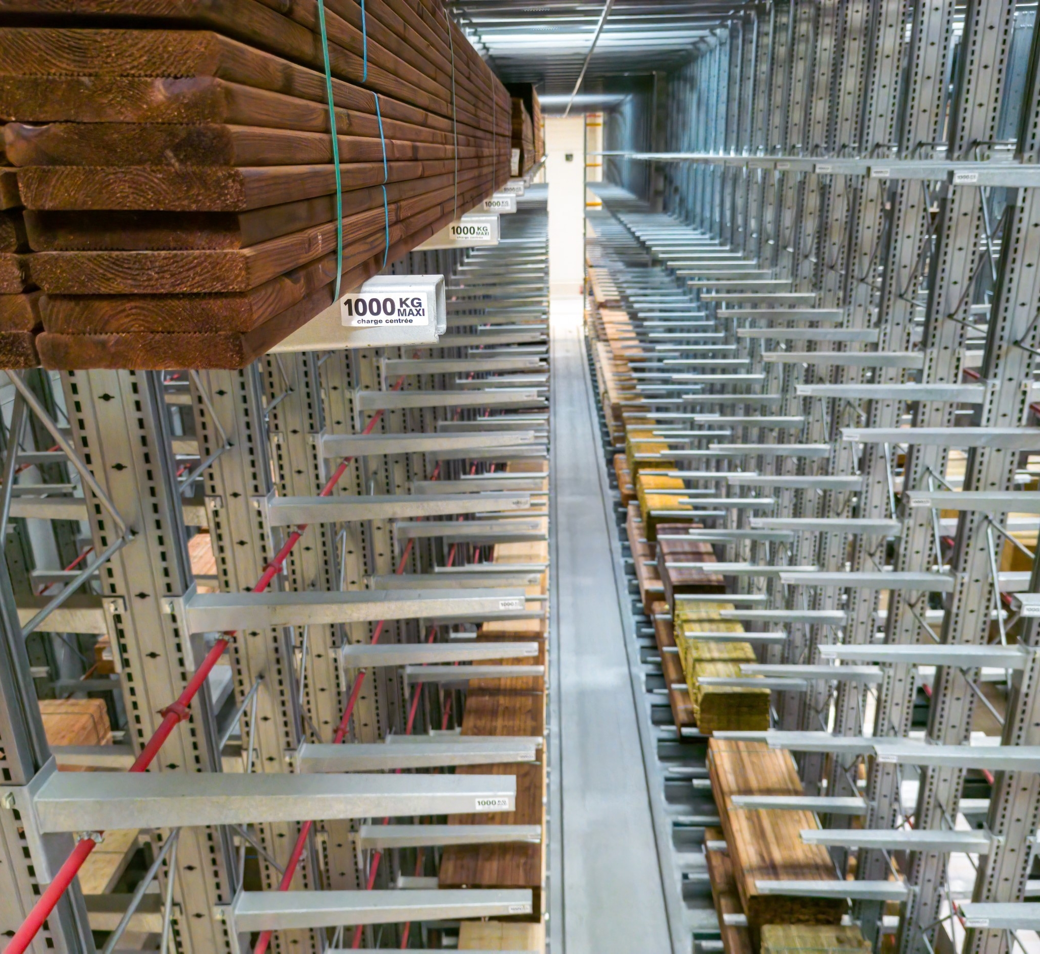 Stockage de bois en hauteur sur des bras de rayonnages cantilever adaptés aux charges lourdes
                