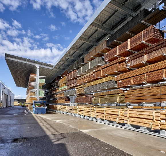 Stockage de bois en hauteur sur des rayonnages cantilever en extérieur équipés d’auvents
					                    