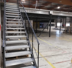 Industriële metalen trap geïnstalleerd in een magazijn om toegang te bieden tot een platform
			