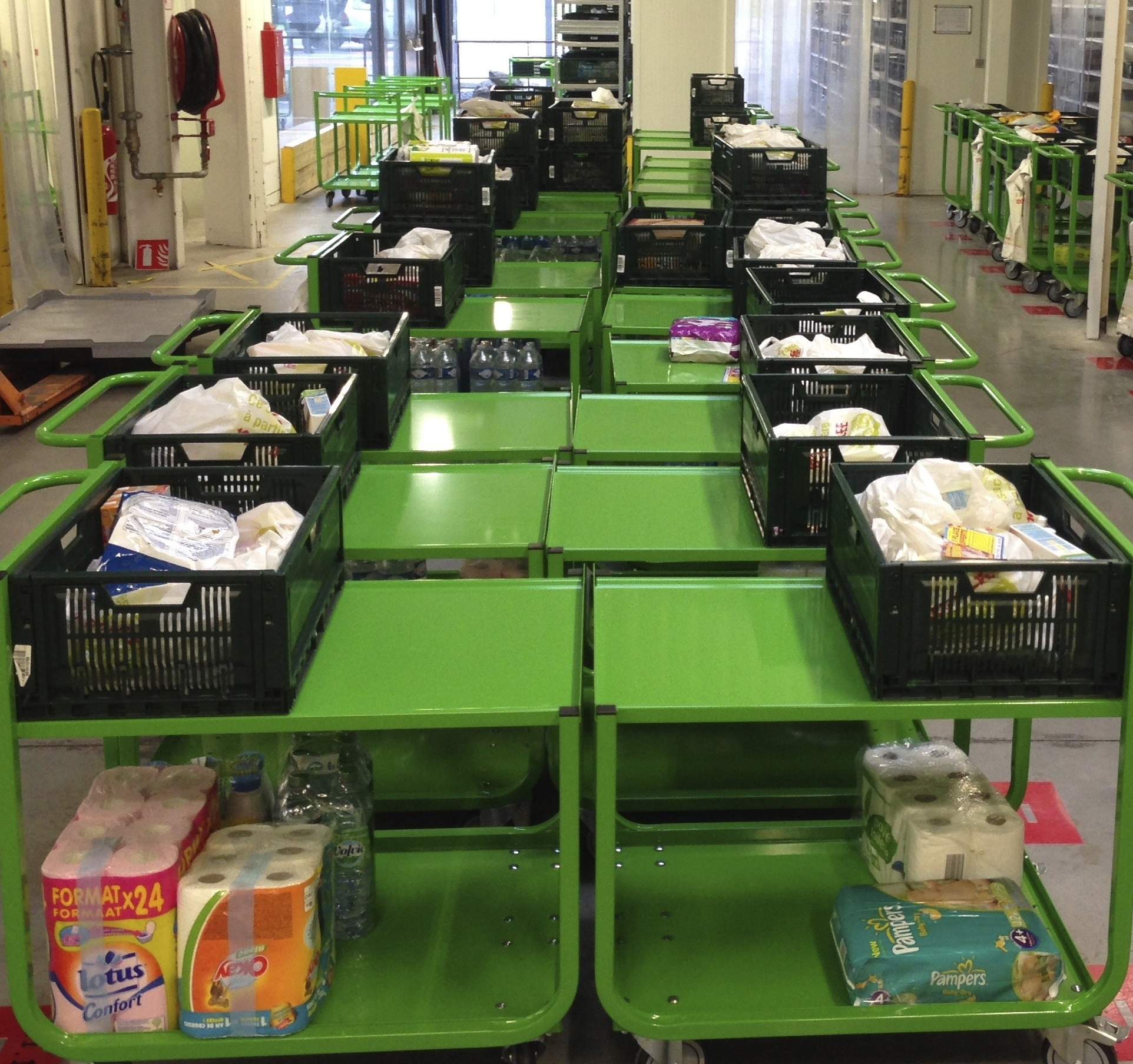 Orderverzameltrolleys opgeslagen in een drive-in magazijn
													