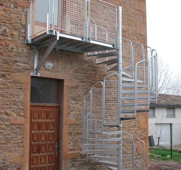Stalen wenteltrap die van buitenaf toegang geeft tot de 1e verdieping van een gebouw
					                    