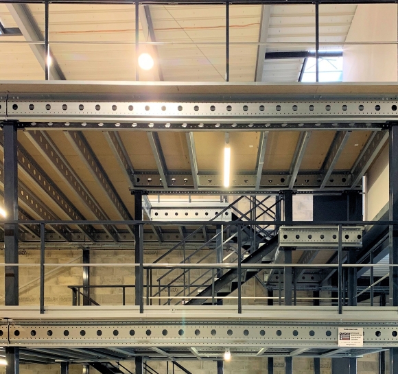 Dubbele metalen trap die toegang biedt tot verschillende niveaus van een platform in een magazijn]
		                    