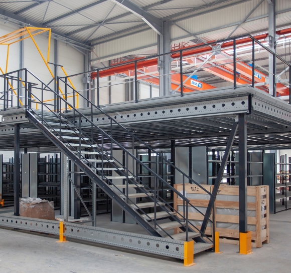 Metalen mezzanine op één niveau met trap en sluisdeur in een magazijn
													